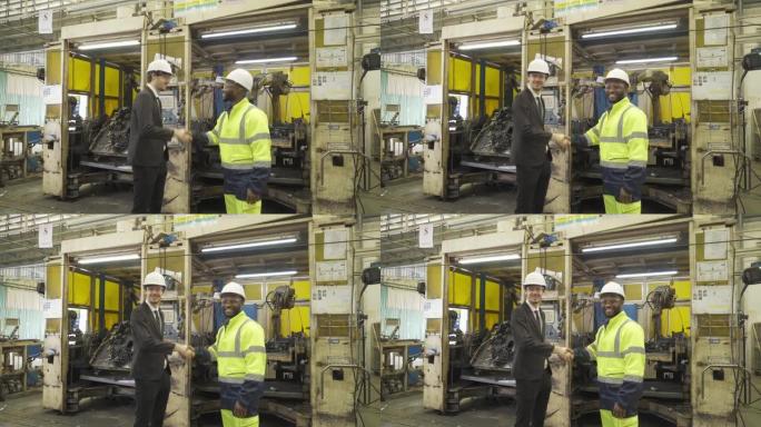 西方商人肖像，高加索人和非洲黑人，工程师团队握手，控制智能机器人焊接手系统自动制造机器发动机在工厂，