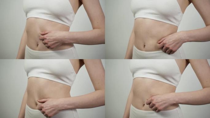 无法辨认的白人妇女检查腹部皮肤状况的特写镜头。
