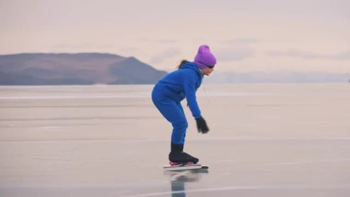 女孩在冰上速滑训练。孩子在冬天穿着蓝色运动服和运动眼镜滑冰。儿童速滑运动。