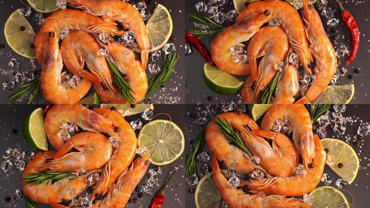 冰中新鲜生橙虾的俯视图在黑石切菜板上旋转。用柠檬，酸橙，辣椒，盐和迷迭香关闭虾。海鲜背景