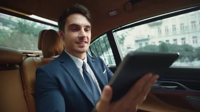 快乐男性专业人士在商务车平板电脑上阅读信息。