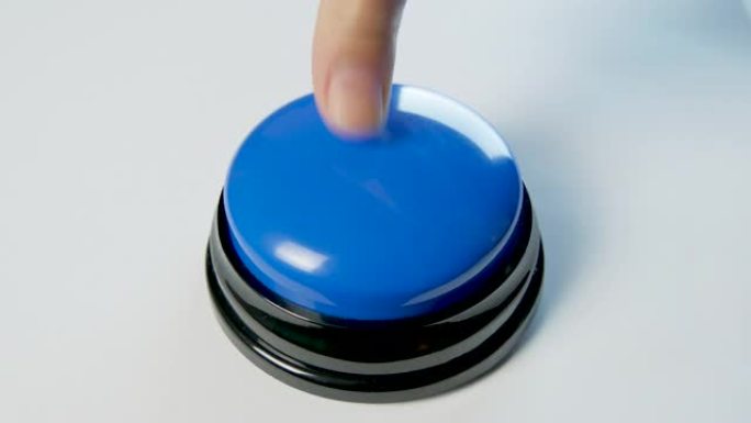 年轻女子用手指和手掌按下蓝色按钮。按下圆形光泽按钮，俯视图。激活，发射一些东西。打开和关闭。