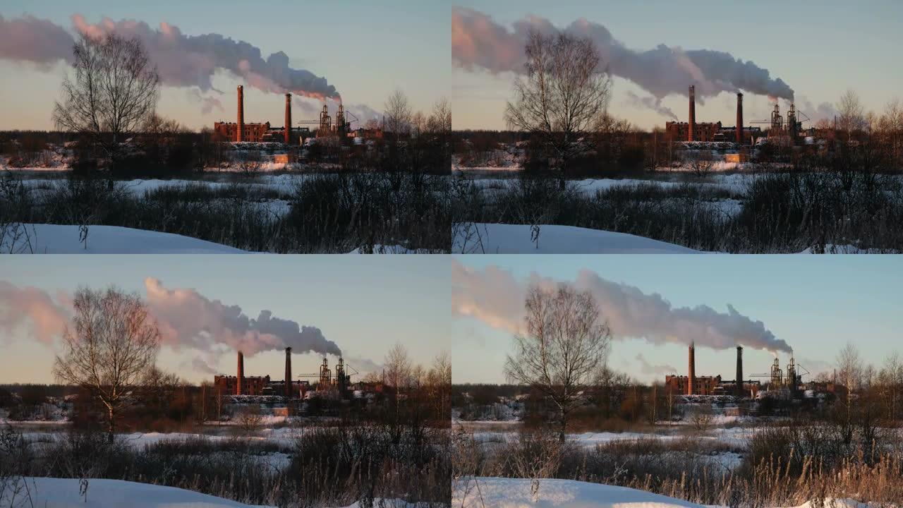 工厂管道在日落时冒烟。