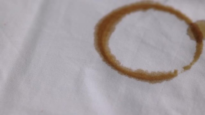 一件沾有棕色咖啡渍的白色棉质衬衫。必须在洗衣机中彻底清洗
