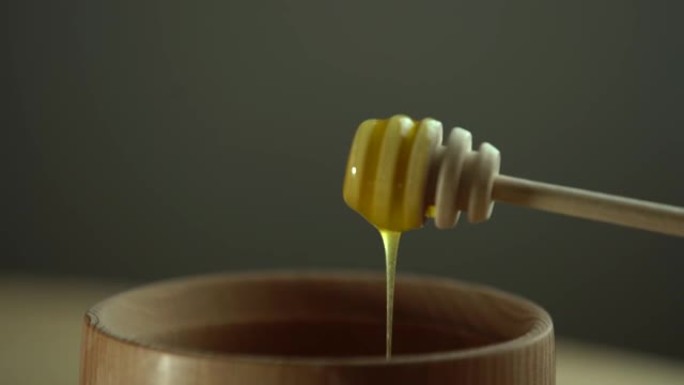 从勺子里滴下浓稠的蜂蜜，特写。从勺子里流出蜂蜜的蜂蜜