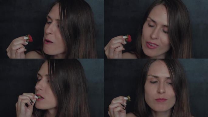 性感的年轻女孩用红色口红吃草莓