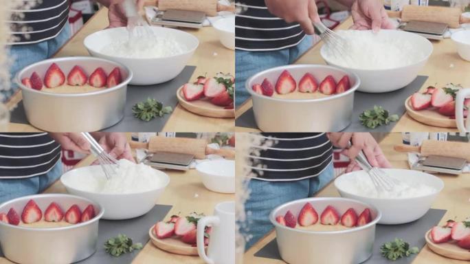 在家里的厨房里做饭和甜点在铝锅旁边的白色杯子里用手搅拌器搅拌和敲打蛋糕的特写镜头，下面是一片草莓和粗