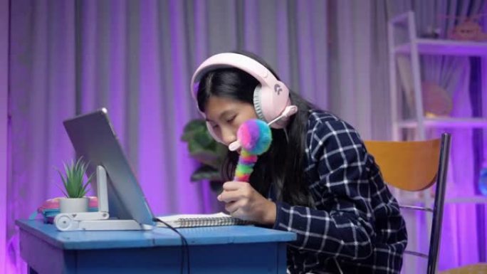 亚洲女学生在家学习数字平板电脑在线课程，带发光二极管背景，社交距离生活方式概念。