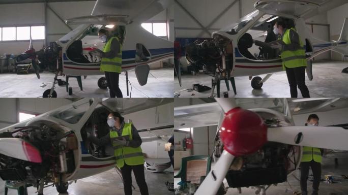 飞机工程师在飞机机库中检查飞机发动机，然后将其放回飞行。