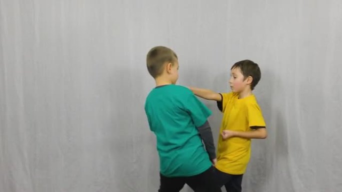 在浅色背景下，两名穿着彩色t恤的运动员训练障碍，拳打脚踢