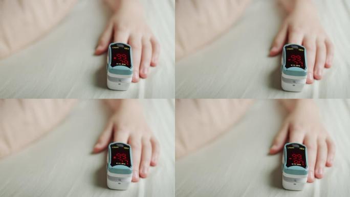 孩子的手在手指上有一个心率监测器，测量脉搏和血氧饱和度