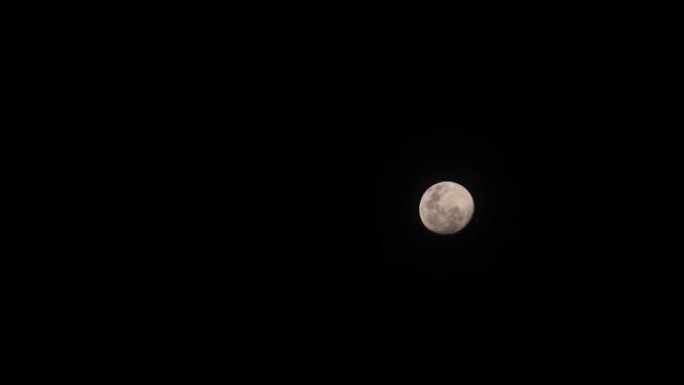 满月之夜在黑暗晴朗的天空中。月球行进的垂直线在太空中上升。圆圆美丽的满月在春天来临的夜晚庆祝晚会。夜
