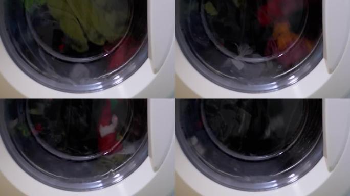 用家用洗衣机洗彩色衣服。旋转滚筒。4K