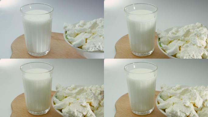 新鲜的开菲尔将天然奶酪放在木托盘上，在玻璃杯中放入乳制品天然开菲尔。酸奶配奶酪