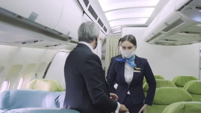 商务舱的飞行出勤帮助乘客将行李存放在飞机的机舱高架行李箱中。顶部隔层搁板上的随身行李箱。旅游和商业概