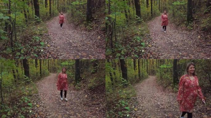 孕妇在秋天与可卡犬在公园小径上行走