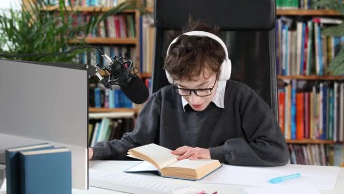 教育学习在线概念，青少年学生戴耳机使用计算机在线学习。一个聪明的小男孩用电脑和他的老师视频聊天。电子