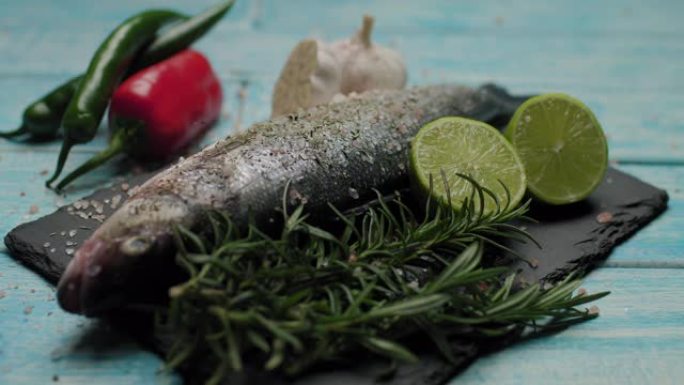 将草药倒在鲜鱼上。准备在烤架上烹饪鲈鱼。用香料和盐煮鱼。装饰鱼菜。