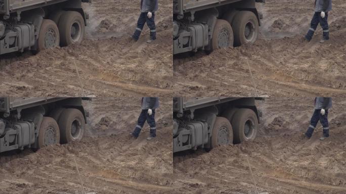 一辆建筑卡车停在沙子里。中央差速锁，背景，行业。车轮抓地力