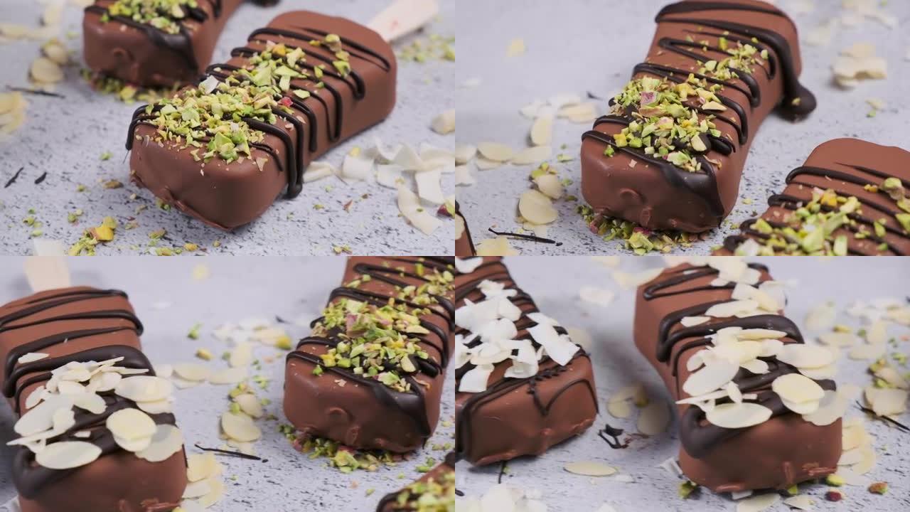 巧克力冰淇淋冰棒撒上杏仁、椰子和开心果，特写镜头。黑巧克力素食冰淇淋