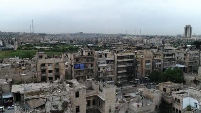 一辆汽车行驶在叙利亚城市的道路上。一些建筑在10年前的内战后仍然是废墟- 4K无人机的鸟瞰图