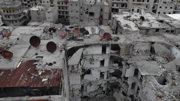 叙利亚阿勒颇建筑屋顶上方的鸟瞰图。屋顶上有被时间锈蚀的天线，建筑在4K废墟中