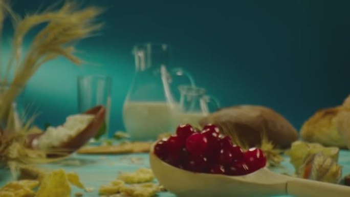 装饰桌子的美丽组成与牛奶乳制品，面包店，浆果，蓝色背景上的花朵。在慢动作的ARRI相机上近距离拍摄的