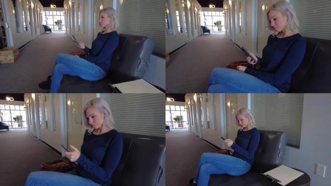 年轻的白人女性在商务候车室等待预约使用技术4k视频系列