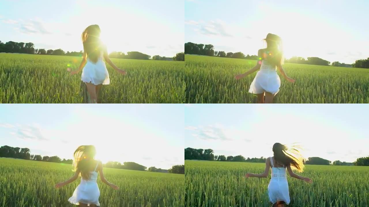 美丽的女孩在日落的麦田上玩耍