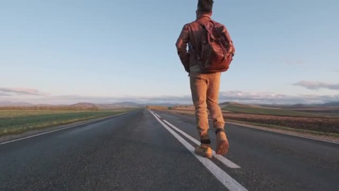 时髦的搭便车旅游旅行者，背着背包沿着道路行走