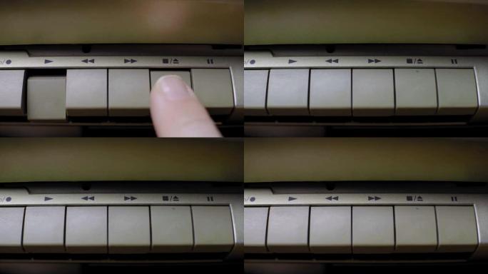 手指按下旧复古磁带播放器上的停止按钮，特写