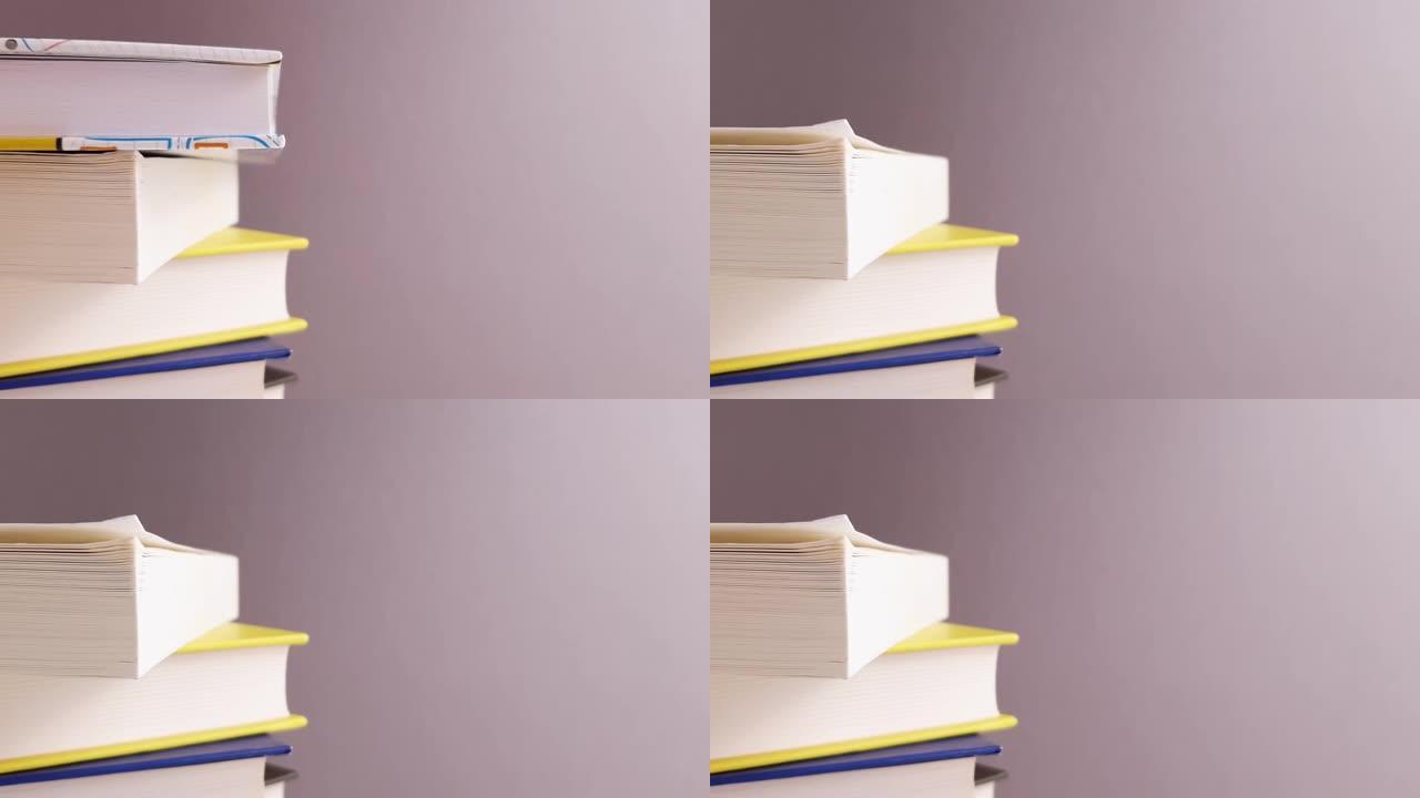 书籍堆积在框架中央的白色灰色背景上的不同颜色，其中一本书带有复制空间的教育学习学校学习研究概念。