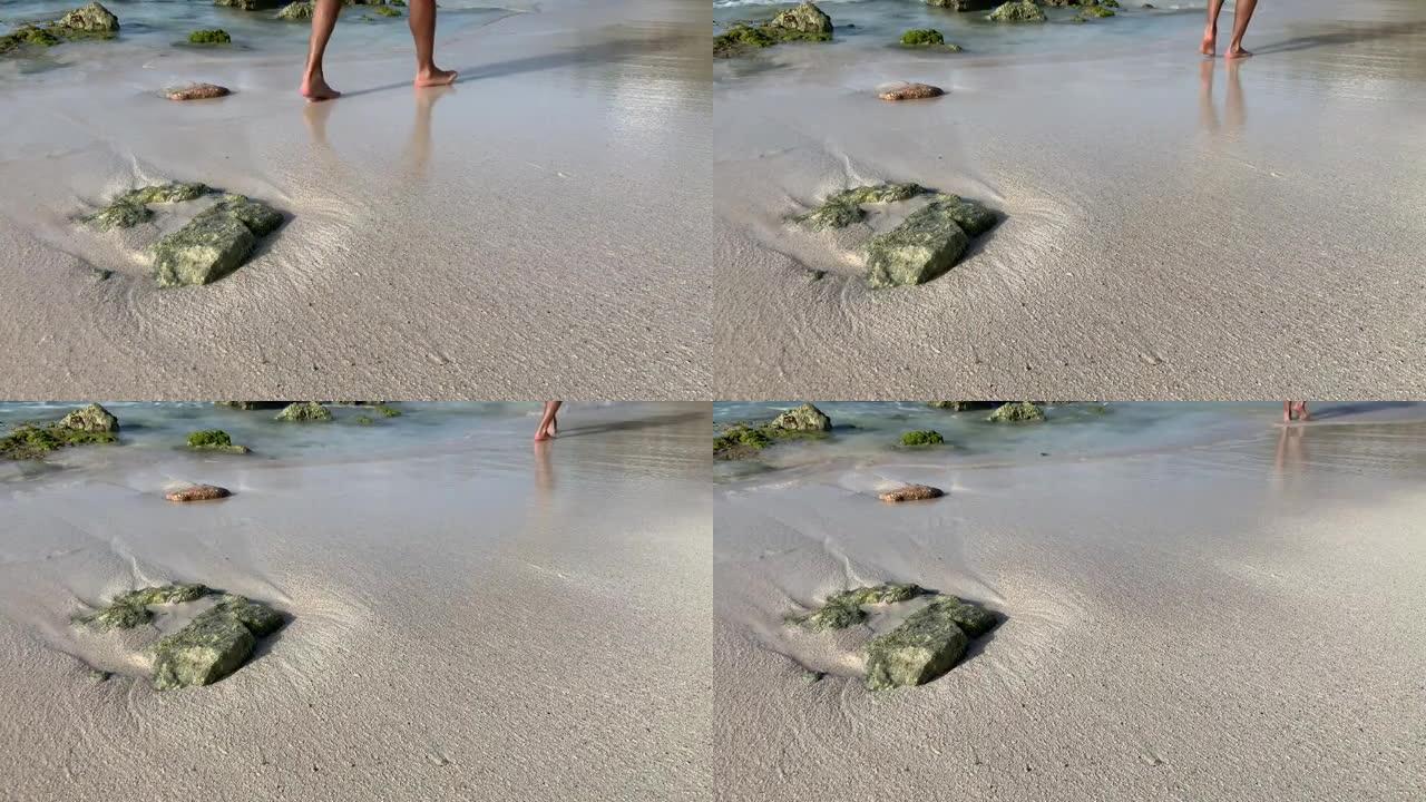 当加勒比海海浪撞击裸露的岩石时，男性壮举将水溅到潮湿的沙滩上。
