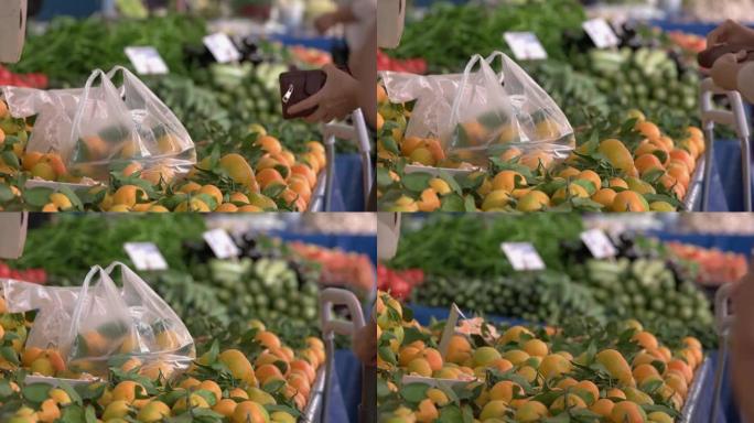 女人在水果市场买水果的特写镜头。