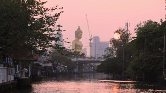 从泰国曼谷的Khlong Bangkok Yai日落时看到的大金佛像 “Phra buddha Dh