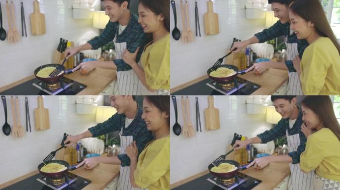 年轻的已婚夫妇正在家里浪漫的气氛中帮忙做饭。情侣们在厨房里通过互相帮助做早餐来表达爱意。