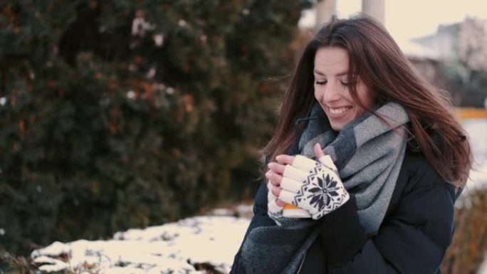 快乐女孩在冬季公园散步时喝咖啡外卖