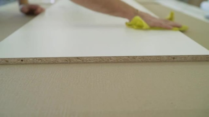 白色中密度纤维板躺在家具厂的桌子上。桌子上有一叠OSB纸。建筑材料。OSB床单堆叠在五金店中。建筑材