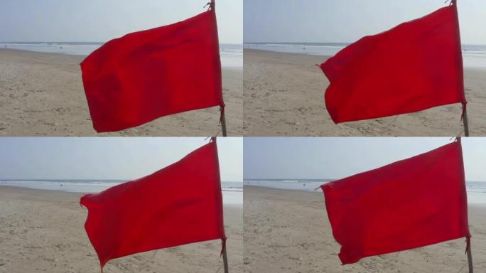 一个明亮的红旗的特写与海滩和海洋的背景