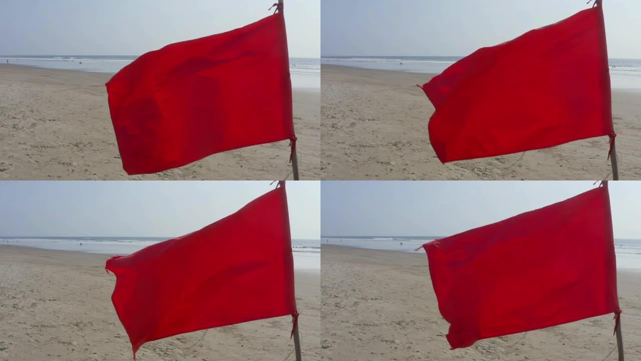 一个明亮的红旗的特写与海滩和海洋的背景
