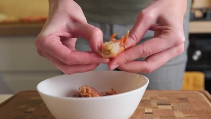 手剥虾壳的过程。女人清洗虾做饭