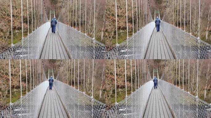 一名男子在苏格兰下河的悬索桥上走来走去