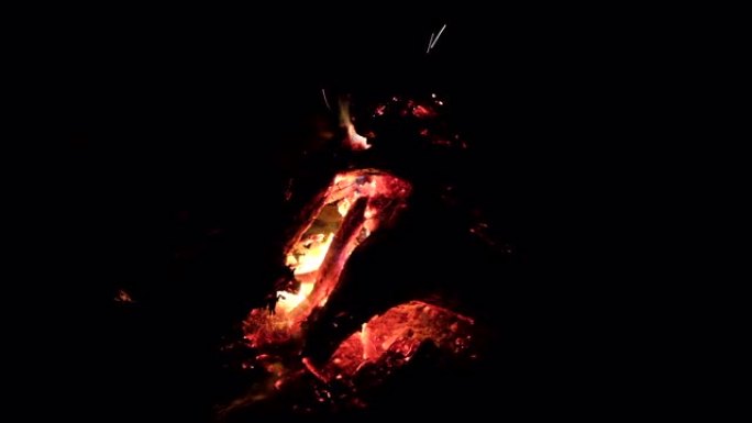 美丽的壁炉特写，晚上有红色的煤和火。晚上篝火或壁炉的特写。暖化概念。