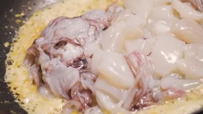 鱿鱼用大蒜和油在锅里炒。海鲜和亚洲菜单。