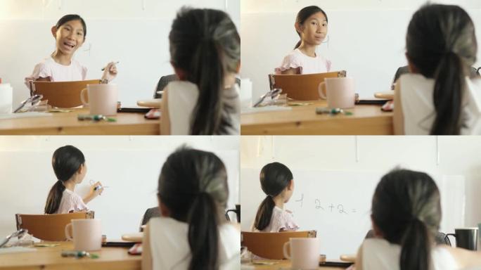 亚洲女孩在新型冠状病毒肺炎期间在家为姐姐在白板上教数学，社交距离概念。
