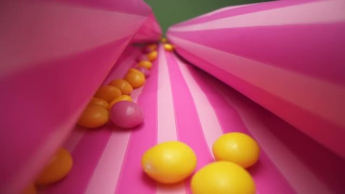 条纹包装纸上的粉色和黄色果冻豆