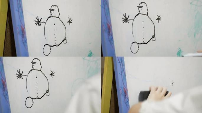 一个小女孩的手的特写镜头，她在白板上用黑色的火焰画。迷人的小女孩在白板上用黑色记号笔画画