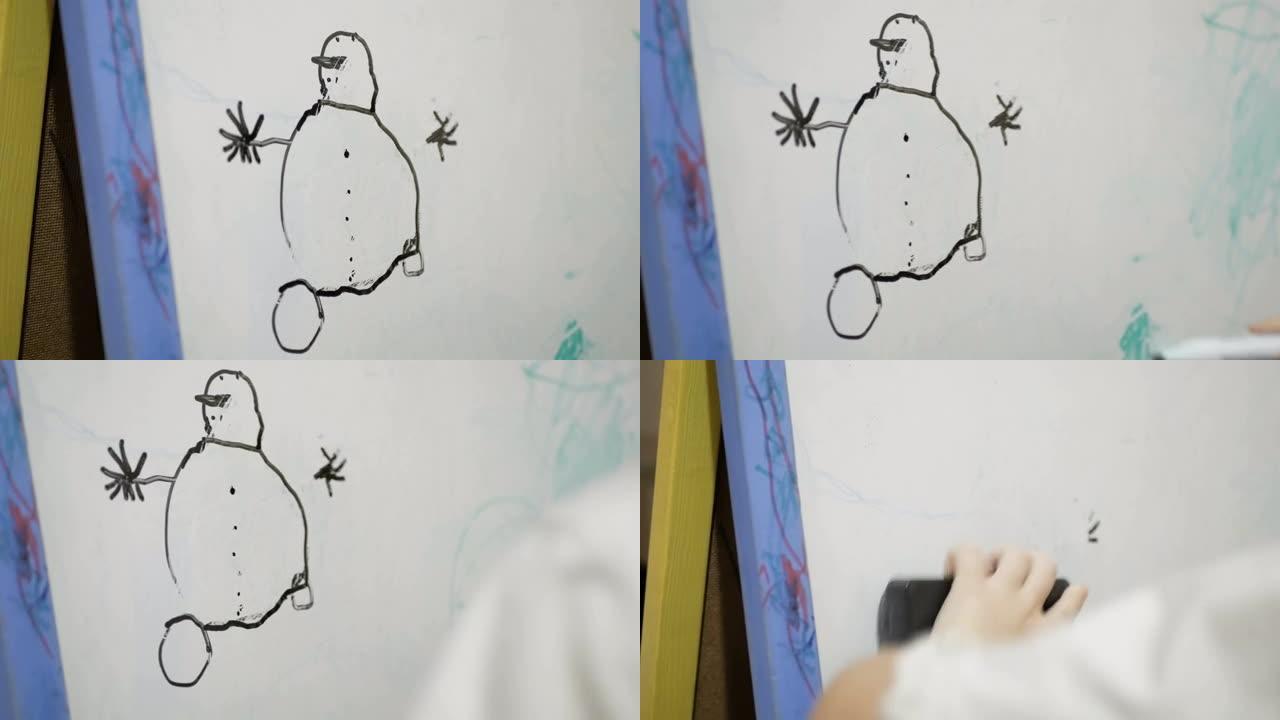 一个小女孩的手的特写镜头，她在白板上用黑色的火焰画。迷人的小女孩在白板上用黑色记号笔画画