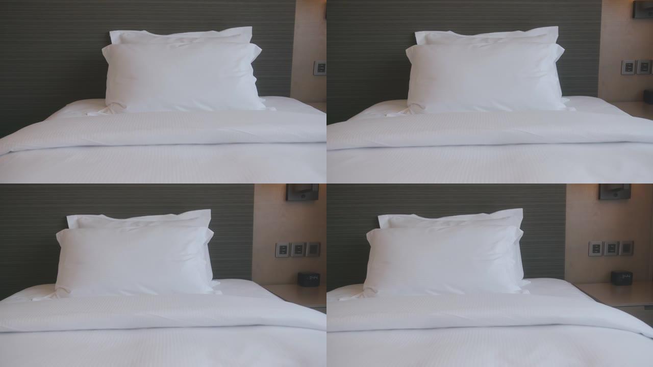 多莉拍摄的4k镜头美丽休闲白色柔软枕头和床单卧室舒适放松室内设计家居室内细节概念