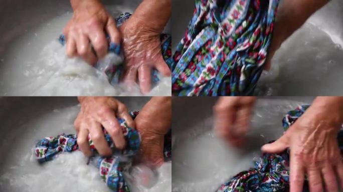 混合种族妇女的老年皱纹手在洗手洗衣时皱巴巴的彩色纺织品连衣裙